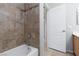 Close up of a neutral-tiled shower/tub combo with a showerhead, and brushed metal fixtures at 1709 Pacific Panorama Pl, Las Vegas, NV 89144
