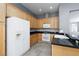 Spacious kitchen with black countertops, wood cabinets, and stainless steel appliances at 1709 Pacific Panorama Pl, Las Vegas, NV 89144