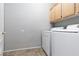 Functional laundry room with tile floors, storage cabinets, and a washer and dryer at 1709 Pacific Panorama Pl, Las Vegas, NV 89144