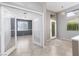 Open living space with tile flooring, features glass doors to another room, and a bright entryway at 1709 Pacific Panorama Pl, Las Vegas, NV 89144