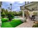 Outdoor dining area with lush landscaping and a pool, creating a perfect setting for outdoor entertainment at 2338 Dolphin Ct, Henderson, NV 89074