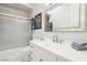 Bright bathroom featuring a shower-tub combo with glass doors and a modern vanity at 2338 Dolphin Ct, Henderson, NV 89074