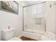 Bright bathroom featuring a tub with sliding glass door, toilet, and decorative wall art at 2338 Dolphin Ct, Henderson, NV 89074