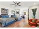 Bright bedroom featuring two beds, hardwood floors, ceiling fan, desk, and comfortable seating area at 2338 Dolphin Ct, Henderson, NV 89074