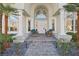 Elegant front entrance with a grand archway, white columns, and decorative chairs flanking the doorway at 2338 Dolphin Ct, Henderson, NV 89074