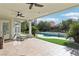 Covered patio with ceiling fans offering views of the pool and lush landscaping, perfect for relaxation at 2338 Dolphin Ct, Henderson, NV 89074