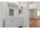 Bathroom vanity with white cabinets, marble countertop and wood-look flooring at 283 Grand Olympia Dr, Henderson, NV 89012