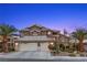 Charming two-story home with a well-manicured front yard and a three-car garage, complemented by mature palm trees at 283 Grand Olympia Dr, Henderson, NV 89012