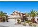 Two-story home with a two-car garage and desert landscaping at 283 Grand Olympia Dr, Henderson, NV 89012