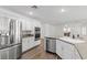 Modern kitchen with stainless steel appliances, white cabinetry, granite counters, and an open layout to the living area at 283 Grand Olympia Dr, Henderson, NV 89012