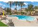 Community pool with seating area surrounded by palm trees and well-maintained landscaping at 3425 E Russell Rd # 155, Las Vegas, NV 89120