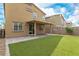 Inviting backyard with artificial turf, a covered patio, and block wall fencing for privacy, perfect for outdoor entertaining at 4512 Moon Hill Rock Ave, North Las Vegas, NV 89084