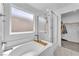 Bright bathroom features a bathtub with shower and a frosted window at 456 Desoto Falls St, Indian Springs, NV 89018