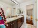 Bathroom with double sinks, dark wood cabinets and access to bedroom and shower at 521 Dawn Cove Dr, Henderson, NV 89052