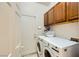 Convenient laundry room with modern washer and dryer, and ample overhead cabinets at 521 Dawn Cove Dr, Henderson, NV 89052