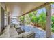 Covered patio with an elegant outdoor seating area and lush landscaping at 521 Dawn Cove Dr, Henderson, NV 89052