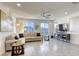 Bright living room with tile floors, large windows, a ceiling fan, and a comfortable sectional sofa at 5368 Knitmore Ct, Las Vegas, NV 89139