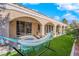 Inviting backyard covered patio with ceiling fans, plenty of seating with lush artificial grass, perfect for relaxing at 9155 Bush Poppy Ave, Las Vegas, NV 89147