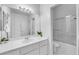 Clean bathroom with large mirror, white vanity and cabinets, and a shower over the tub at 9155 Bush Poppy Ave, Las Vegas, NV 89147