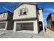 Two-story home featuring an open garage, neutral stucco, and stylish architectural details at 9556 Hinson St, Las Vegas, NV 89139