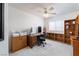 Bright bedroom features a ceiling fan, a built-in bookcase and a wooden desk at 9604 Summer Cypress St, Las Vegas, NV 89123