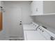 Functional laundry room equipped with a washer, dryer, and storage cabinets at 9604 Summer Cypress St, Las Vegas, NV 89123