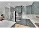Well-equipped kitchen with stainless steel appliances, quartz countertops, and modern light-green cabinetry at 10038 W Meranto Ave, Las Vegas, NV 89178