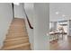 Wooden staircase featuring modern design and neutral tones, leading to the upper level at 10038 W Meranto Ave, Las Vegas, NV 89178