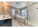 Bright bathroom featuring a double sink vanity, a separate tub, and a glass enclosed shower at 10042 Bismuth St, Las Vegas, NV 89183