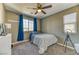 Cozy bedroom with a ceiling fan, window with blue curtains, carpet, and natural light at 10042 Bismuth St, Las Vegas, NV 89183