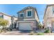 A two-story Gathering home with neutral stucco, complemented by a two-car garage and a well-manicured brick driveway at 10042 Bismuth St, Las Vegas, NV 89183