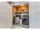 Modern laundry room featuring side-by-side washer and dryer with built in shelving at 10042 Bismuth St, Las Vegas, NV 89183