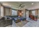 Spacious living room with a plush sectional sofa, ceiling fan, and ample natural light at 10042 Bismuth St, Las Vegas, NV 89183