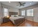 Spacious bedroom featuring hardwood floors, a ceiling fan, and an inviting bed at 10250 Tree Blossom Ave, Las Vegas, NV 89166
