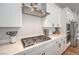 Close up of kitchen features including quartz countertops, stainless steel gas cooktop and vent hood, and white cabinetry at 10250 Tree Blossom Ave, Las Vegas, NV 89166