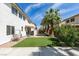 Expansive backyard featuring a patio, lush artificial grass, and mature landscaping with palm trees at 1223 Starstone Ct, Henderson, NV 89014