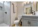 Cozy bathroom features modern vanity with a stone countertop, designer wallpaper and tiled shower at 1223 Starstone Ct, Henderson, NV 89014