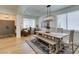 Dining area features a modern chandelier, farmhouse table, bench seating, and wood floors at 1223 Starstone Ct, Henderson, NV 89014