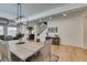 Bright dining room features modern light fixture, light wood floors, and flows into the kitchen at 1223 Starstone Ct, Henderson, NV 89014