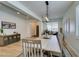 Dining area features a modern chandelier, farmhouse table, bench seating and wood floors at 1223 Starstone Ct, Henderson, NV 89014