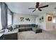 Spacious living room showcasing large gray sectional sofa, neutral carpet and a view of hallway entrances at 1223 Starstone Ct, Henderson, NV 89014