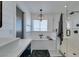 A stylish bathroom shows a bathtub, shower with glass and a window for natural light at 1223 Starstone Ct, Henderson, NV 89014