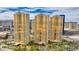 Striking high-rise condos with golden windows and manicured landscaping under a bright blue, cloud-strewn sky at 135 E Harmon Ave # 804, Las Vegas, NV 89109