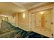 Well-lit hallway featuring decorative carpeting leading to the residence entrance at 135 E Harmon Ave # 804, Las Vegas, NV 89109