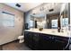 Well-lit bathroom with dark cabinets, double sinks, large mirror, and stylish decor at 1618 Meno Peak St, Las Vegas, NV 89115