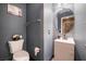 Powder room featuring modern fixtures, vanity, round mirror, and unique wall art at 1618 Meno Peak St, Las Vegas, NV 89115