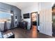 Modern bedroom with wood floors, blue accent wall, dresser with TV, and ensuite bathroom access at 1618 Meno Peak St, Las Vegas, NV 89115