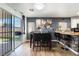 Bright dining area with large sliding glass doors, a stylish table setting, and a kitchen breakfast bar at 1618 Meno Peak St, Las Vegas, NV 89115