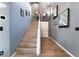 Hallway featuring wood floors, staircase, accent wall, and modern lighting at 1618 Meno Peak St, Las Vegas, NV 89115