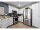Well-lit kitchen featuring stainless steel appliances, bright white cabinets, and plenty of countertop space at 1618 Meno Peak St, Las Vegas, NV 89115